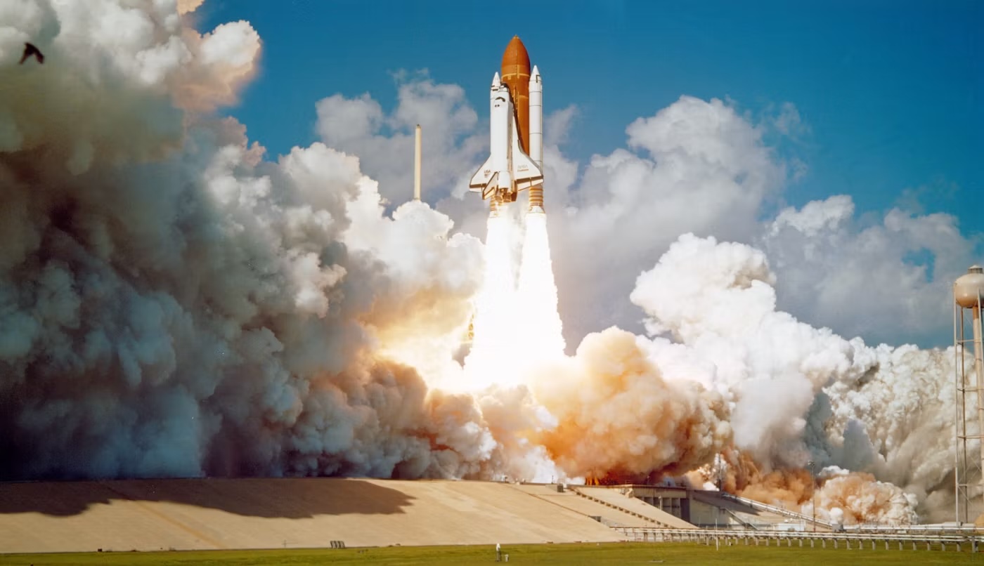 Space shuttle lifting off in a cloud of smoke